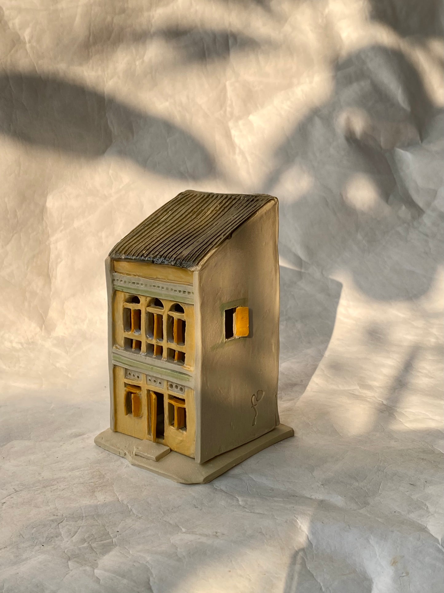 A handbuilt ceramic of Singapore shophouse in yellow color