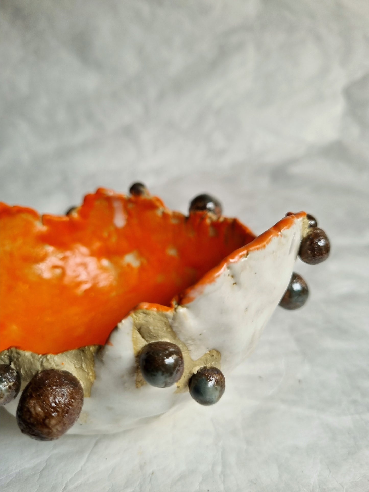 Close-up of a tactile bowl with chocolate pearls on a textured surface