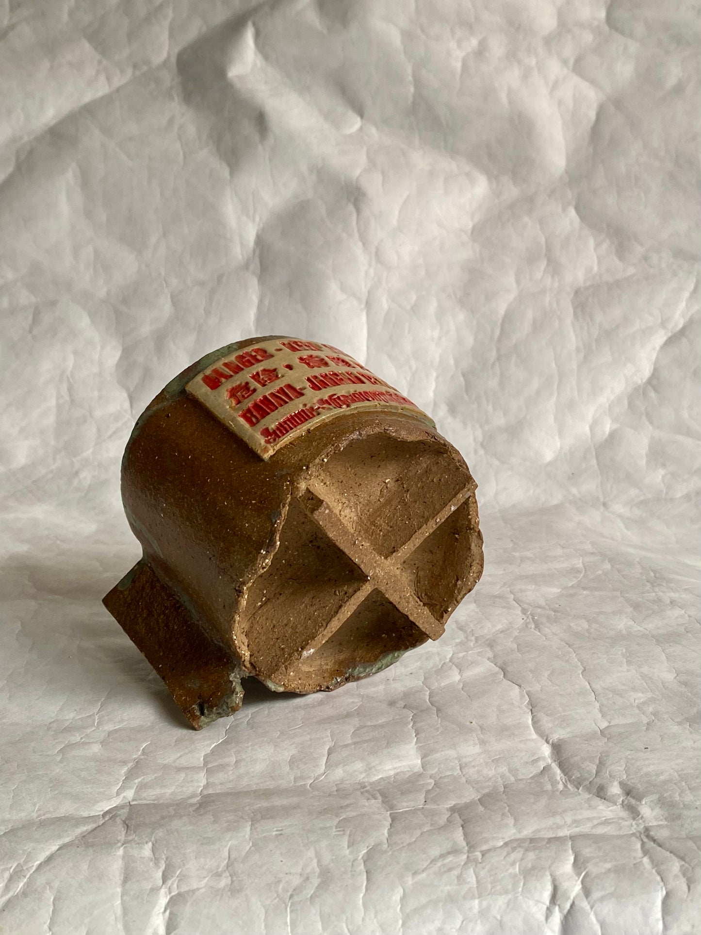 Close-up of hand-carved "Dange- Keep out" signage design on a handbuilt ceramic coffee cup.